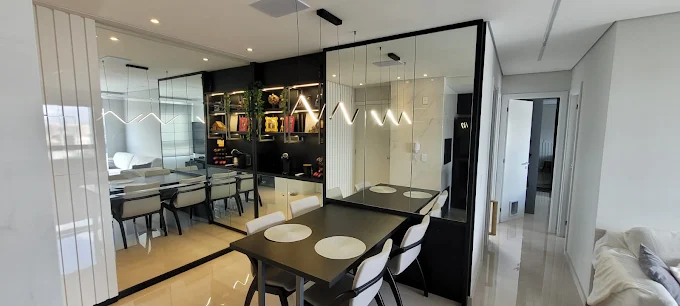 Apartamento Nilo Peçanha — área gourmet com marcenaria escura, espelhos e iluminação indireta